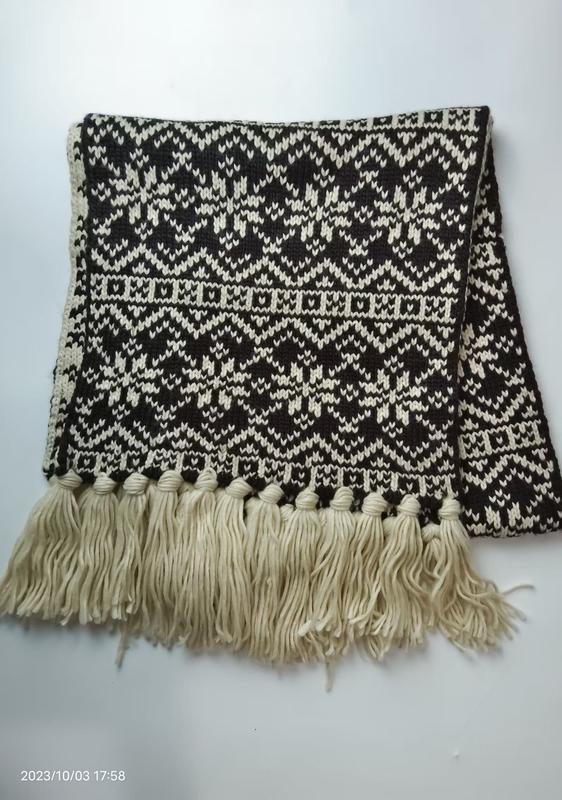 Vikad stickad halsduk i svart/grädde med geometriskt Fair Isle-mönster och tofsar – grossistleverantör vinteraccessoarer.