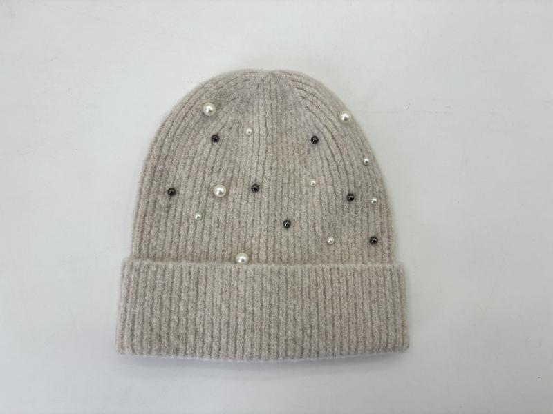 Beige ribbstickad mössa med vita pärlor och mörka kristaller