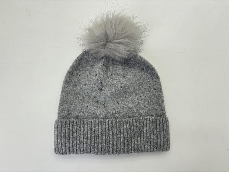 Grå stickad vintermössa med fluffig pompong i konstpäls och strass-detaljer på mudd.