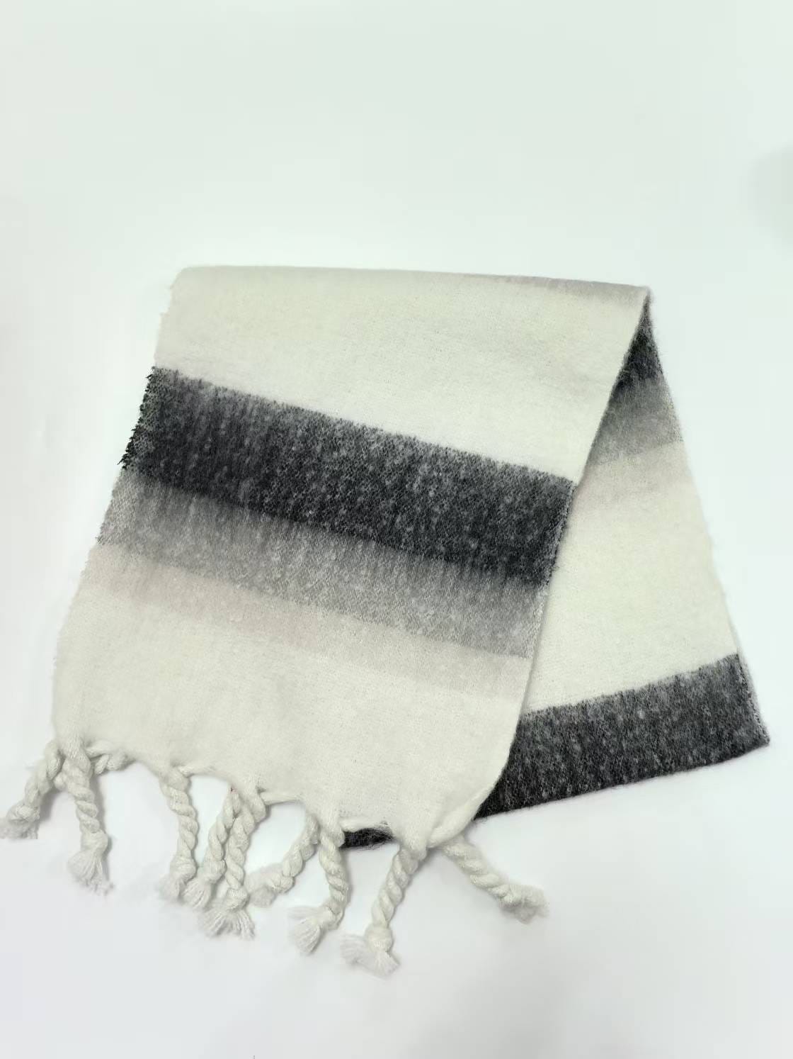 Veckad randig scarf i elfenben och mörkgrå med tvinnat tofsfransar mot vit bakgrund.