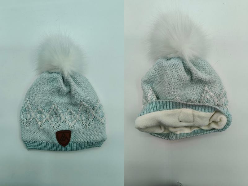 Mintgrön stickad vintermössa med vit pompom i konstpäls