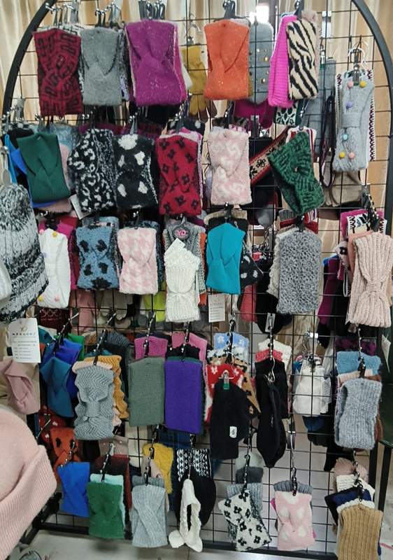Butiksställ med stickade fingervantar och halvvantar i olika färger