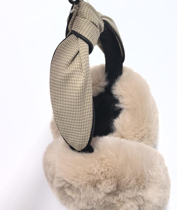 Bruna öronvärmare i sherpa-fleece med justerbart pannband mot vit bakgrund.