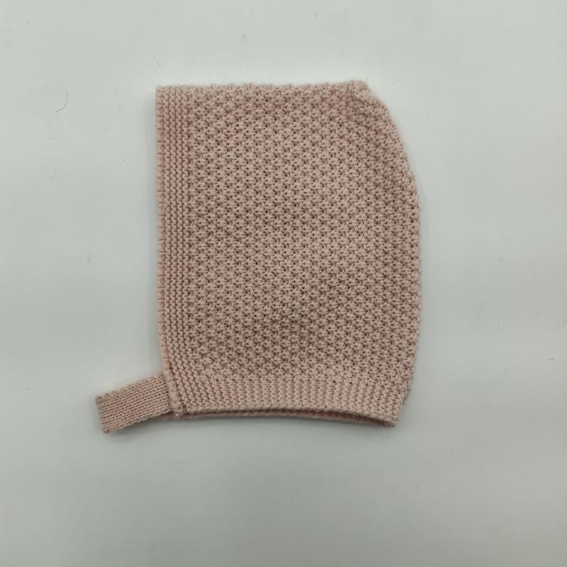 Mjuk rosa stickad babyluva med frömönster och ribbat hakband