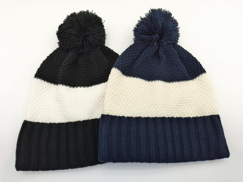 `Svart och marinblå stickad mössa med pompom och färgblock