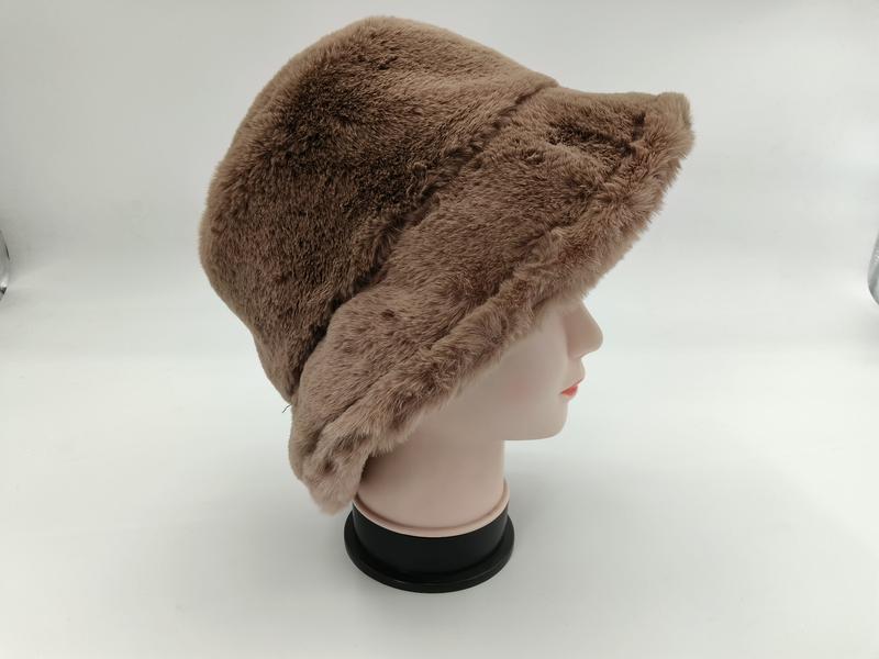 `Brun taupe fluffig hink hatt i konstpäls – varm vinterstil med mjuk plyschmaterial.`