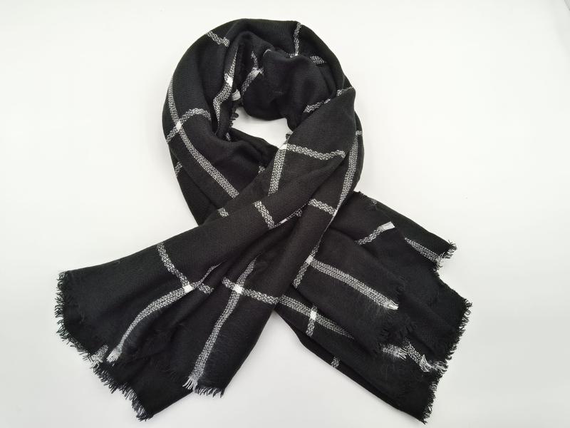 Svart vävd scarf med vitt rutmönster och franjekanter.