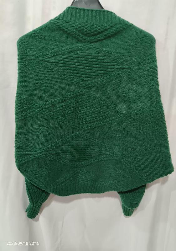 `Bakvy av smaragdgrön chunky stickad poncho med geometriskt diamantmönster – grossistleverantör av knitwear.`