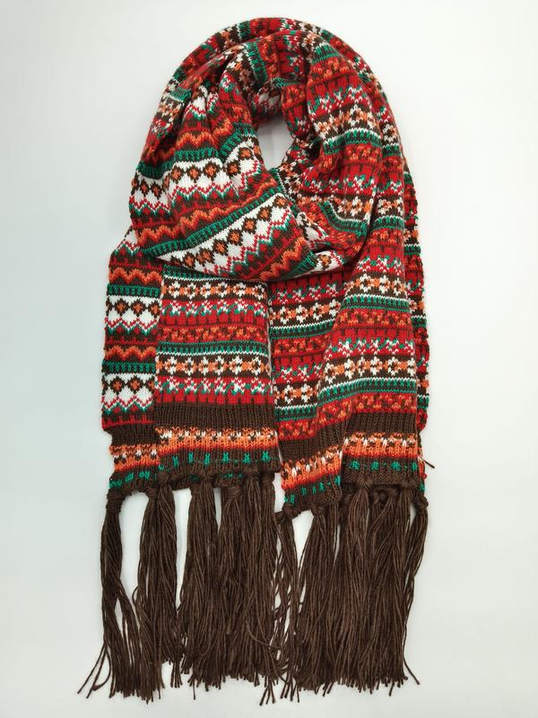 `Röd och grön Fair Isle-stickad halsduk med flerfärgat mönster och bruna fransar i ändarna.`