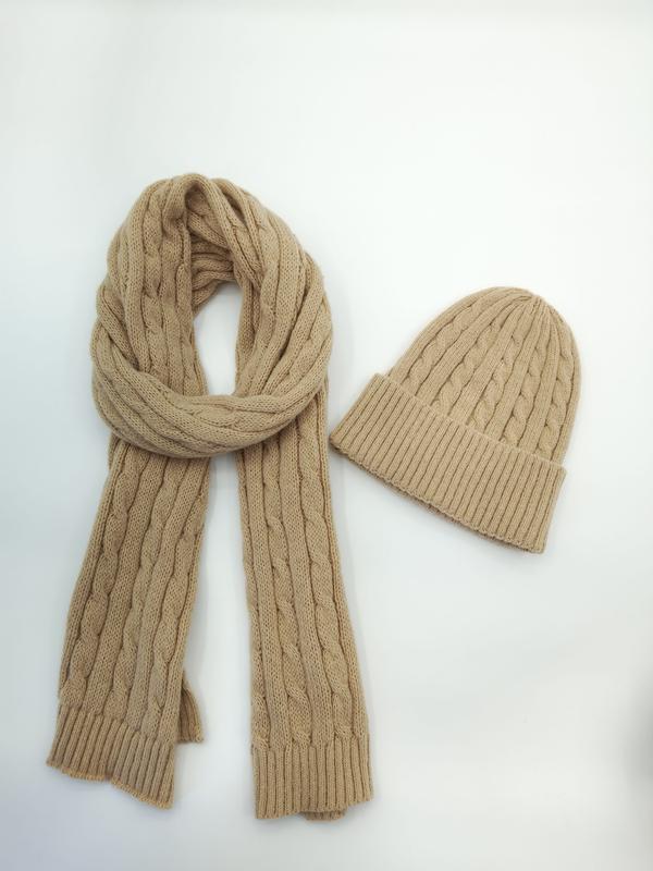 Kamelbeige kabelstickad mössa och scarf mot vit bakgrund.