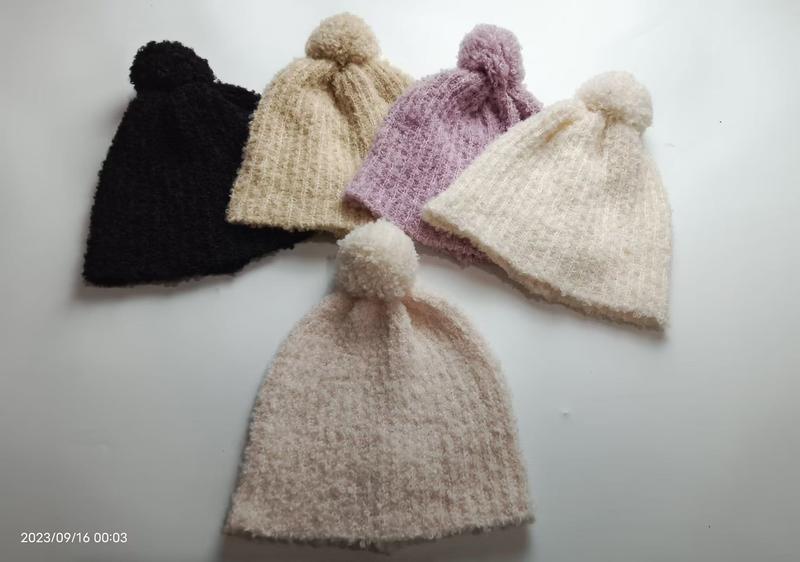 Fem stickade pom-pom mössor i svart