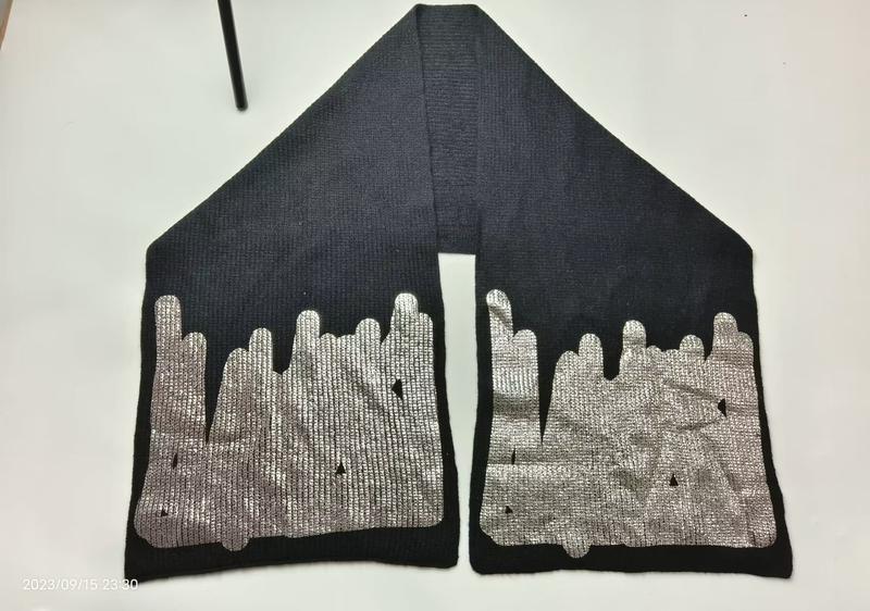 Svart ribbstickad scarf med metallisk silverprint i dropp-mönster på båda ändar – grossist.