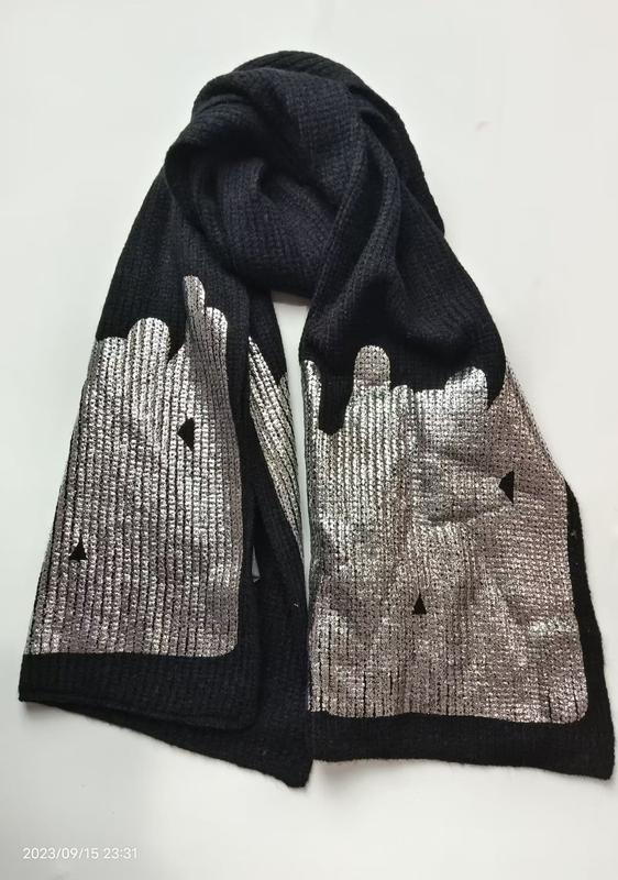 Svart ribbstickad scarf med silvrig metallisk stadssilhuett – grossistleverantör av trendiga accessoarer.