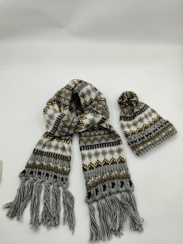 Grå och brun Fair Isle stickad halsduk med fransar och matchande pompongmössa på vit bakgrund.