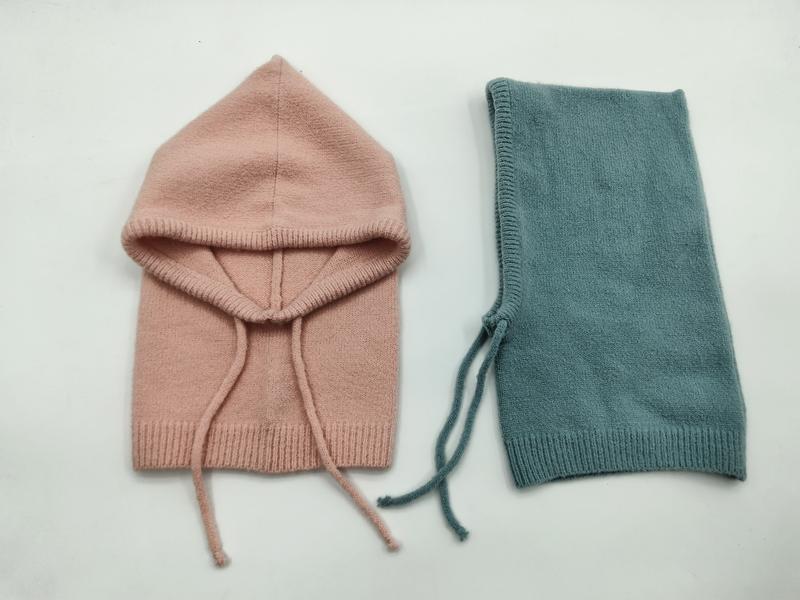 Två stickade babybalaclavor i rosa och teal