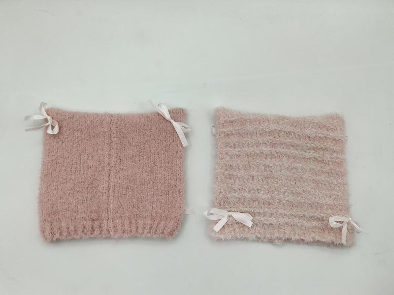 Två rosa stickade stövelvikare med vita satinrosetter