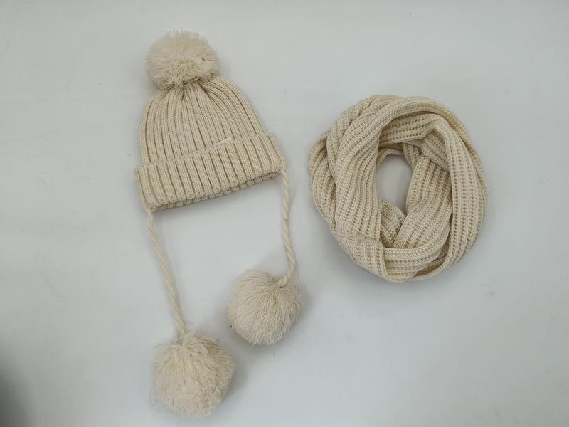 Gräddvit ribbstickad vintermössa med pompom och flätade band
