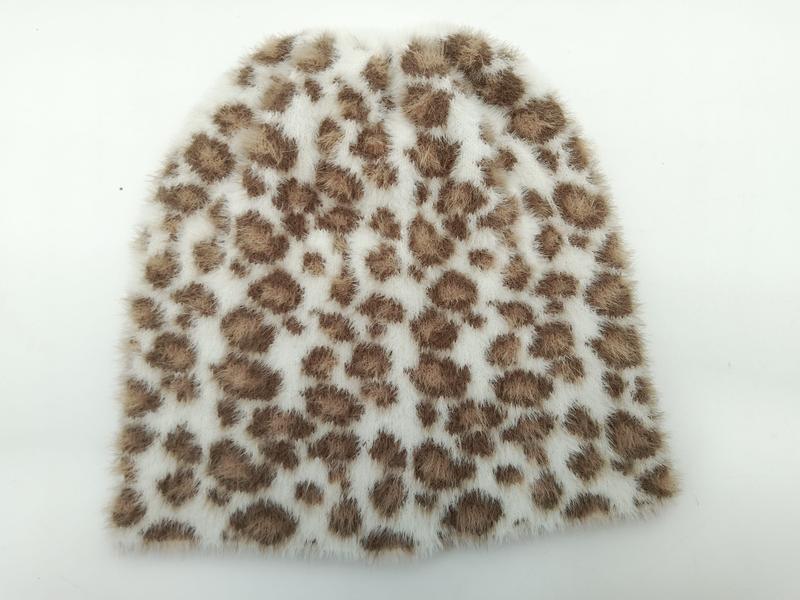 Mjuk vit faux fur-mössa med bruna leopardmönstrade fläckar