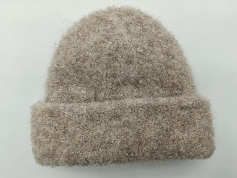 Beige boucléstickat mössa med uppvik och fluffigt texturerat garn