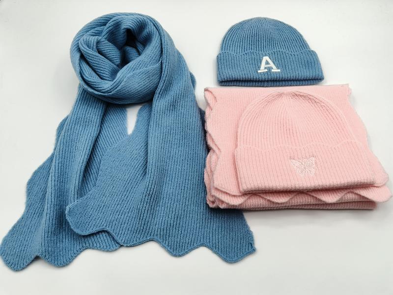 Blå ribbstickad halsduk med bokstaven A och rosa mössa med fjärilsbroderi