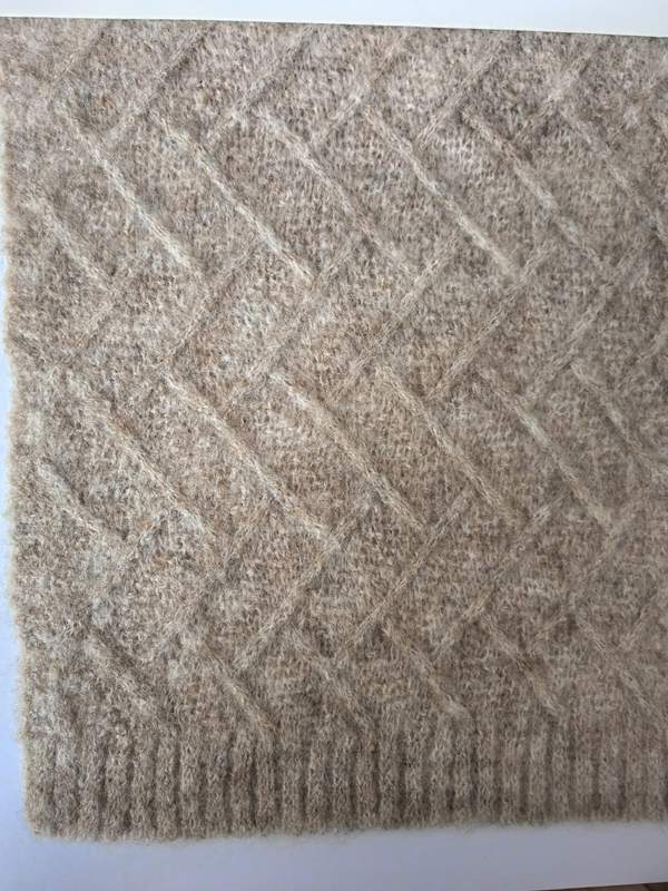 Beige diamantmönstrad stickad ullblandningspläd med ribbad kant – grossistleverantör av premiumtextilier.