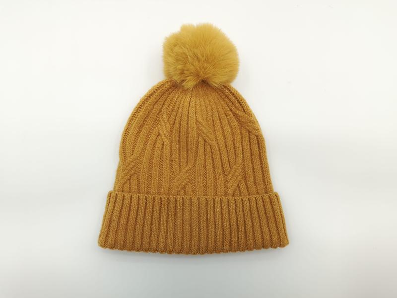 Senapsgul stickad vintermössa med stor fluffig pom pom och ribbad kant