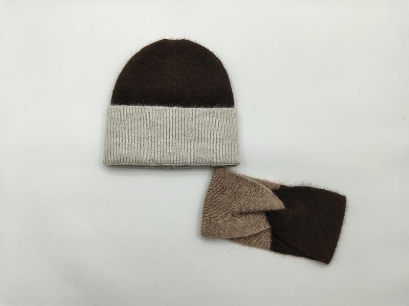 Brun och havregrå stickad mössa med matchande fingervantar utan fingrar i brunt och taupe mot vit bakgrund.