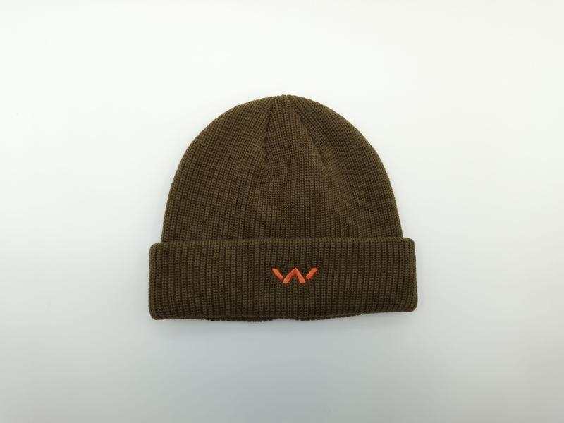 Olivgrön ribbstickad mössa med uppvikt kant och litet orange broderat logotyp
