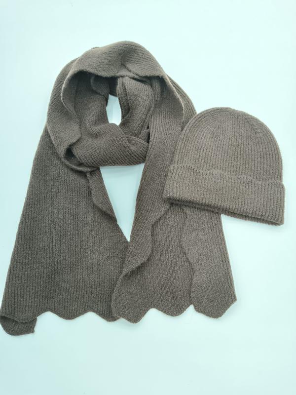 Taupe ribbstickad vinterskjerf med vågkant och matchande uppvikt mössa på ljus bakgrund.
