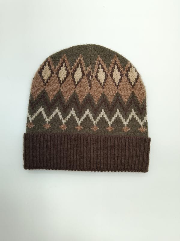 Brun olivgrön och cremefärgad stickad Fair Isle-mössa med revärkant och geometriskt rombmönster på vit bakgrund.