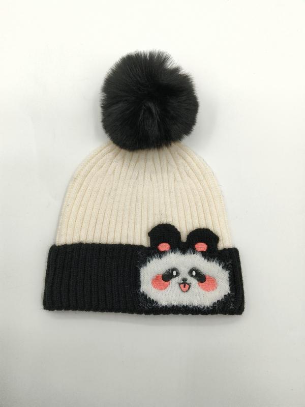 Gräddfärgad och svart ribbstickad mössa med pandamotiv och svart pompong i konstpäls.