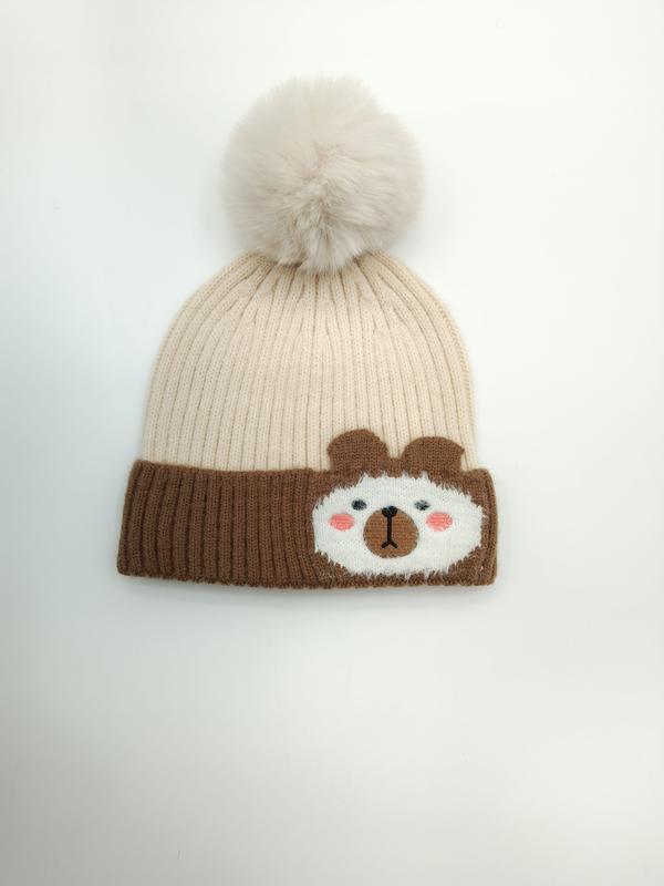 Gräddvit och brun ribbstickad mössa för barn med fluffig pom-pom och söt björnapplikation på uppviket kant.