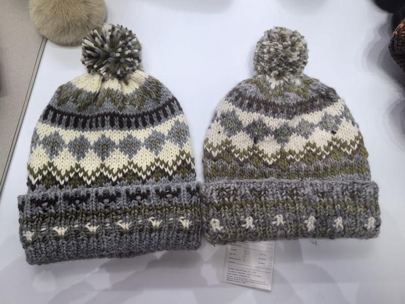 Två stickade Fair Isle-mössor med pompom i grått