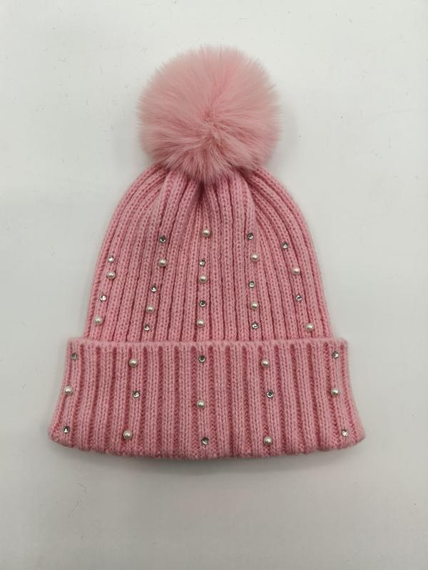 Rosa ribbstickad mössa med konstpälspompon, pärlor och strass.