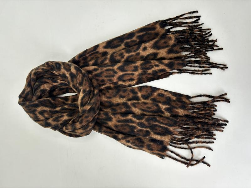 Brun och svart leopardmönstrad scarf i mjukt material med fransar i ändarna, löst knuten mot vit bakgrund.